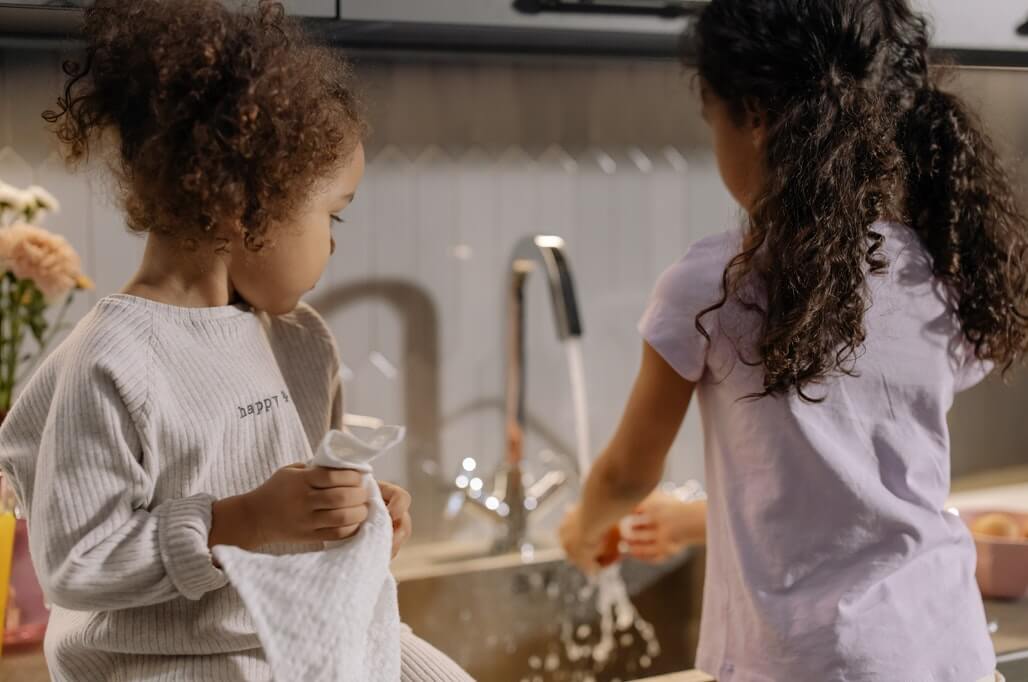children helping parents by washing dishes