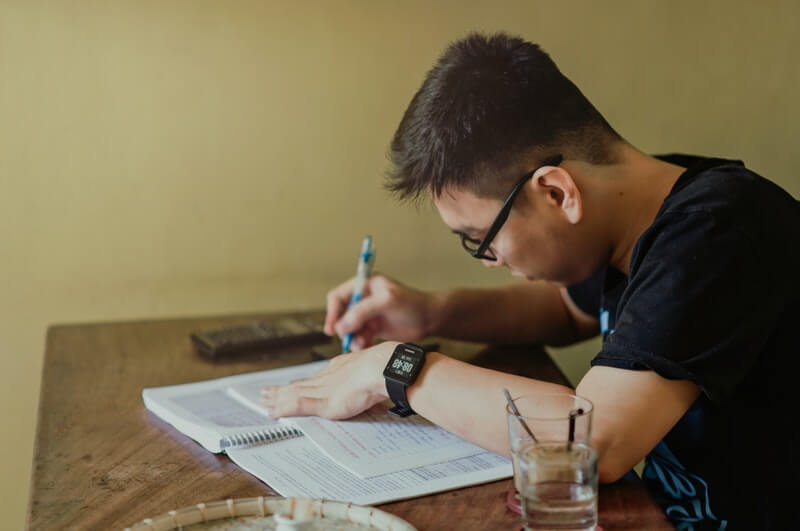 man making a priority list on paper