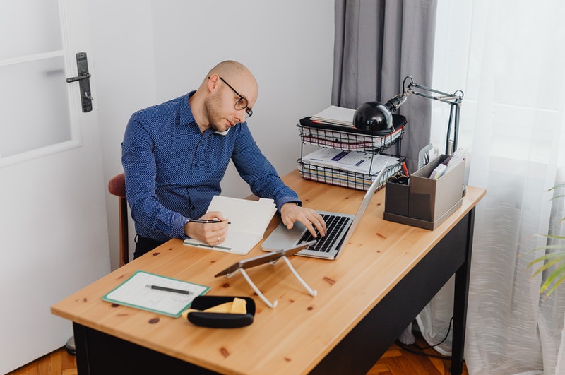 man multitasking while working on a laptop