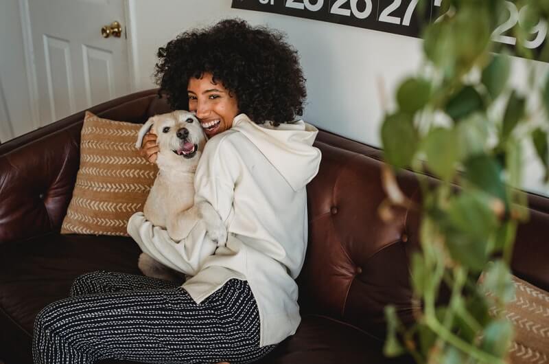 woman holding a puppy while working from home